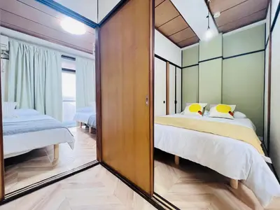 a bedroom with two beds and a mirror at Shinjuku -JX house SJ0284 in Tokyo