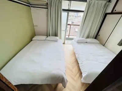 two beds in a small room with a window at Shinjuku -JX house SJ0284 in Tokyo