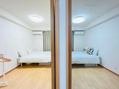 a room with two beds and a room with a mirror at Shinjuku -JX house SJ0284 in Tokyo