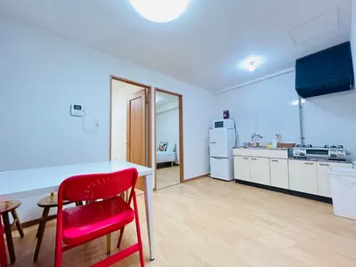 a kitchen with a table and a red chair at Shinjuku -JX house SJ0284 in Tokyo