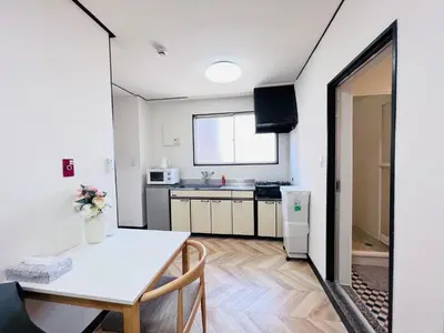 a kitchen and dining room with a white table and chairs at Shinjuku -JX house SJ0284 in Tokyo