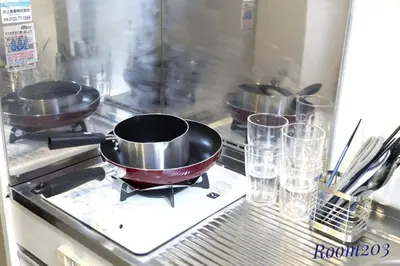 three pans on a stove in a kitchen with glasses at Avanti Room 203-301 - Vacation STAY 68751v in Tokyo