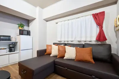 a living room with a black couch with orange pillows at N1-2Shinjuku luxury house with EV Max6P in Tokyo
