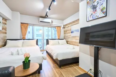 a room with two beds and a flat screen tv at N2-3Shinjuku luxury house with EV Max6P 4min to Sta in Tokyo