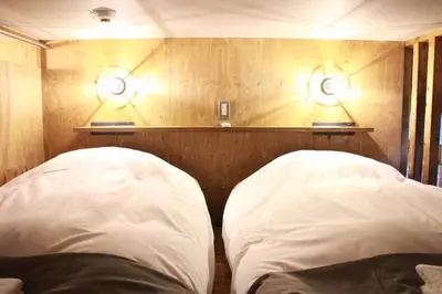 two white pillows in a room with two lights on the wall at Rakuna Inn \u548c Honjo-Azumabashi in Tokyo