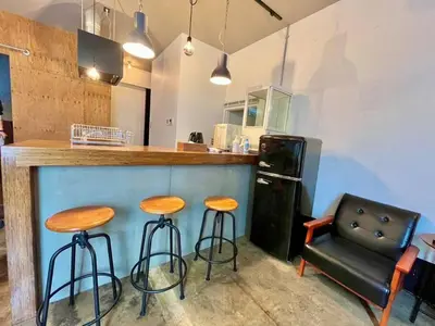 a kitchen with two stools and a bar with a chair at Rakuna Inn \u548c Honjo-Azumabashi in Tokyo