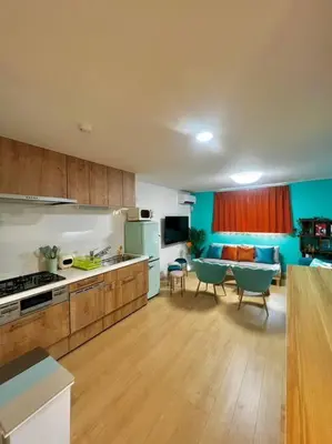 a kitchen and living room with a table and chairs at \u5343\u4f4f\u6cb3\u539f\u753a2f 3f in Tokyo