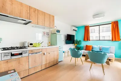 a kitchen with blue walls and a table and chairs at \u5343\u4f4f\u6cb3\u539f\u753a2f 3f in Tokyo