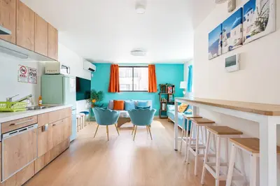 a kitchen with a table and some blue chairs at \u5343\u4f4f\u6cb3\u539f\u753a2f 3f in Tokyo