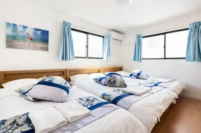 two twin beds in a room with blue curtains at \u5343\u4f4f\u6cb3\u539f\u753a2f 3f in Tokyo