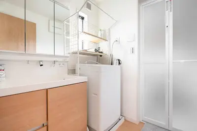 a white kitchen with a sink and a refrigerator at \u5343\u4f4f\u6cb3\u539f\u753a2f 3f in Tokyo