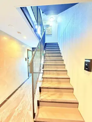a staircase in a building with blue walls and wooden floors at Shinjuku Tokyo Holiday Hotel in Tokyo