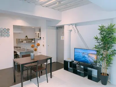 a living room with a dining table and a tv at Fleg Higashi Azabu in Tokyo