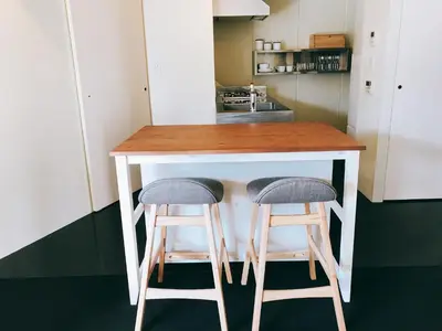 a kitchen with a counter with two bar stools at Fleg Higashi Azabu in Tokyo