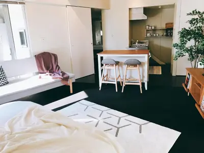 a living room with a table and chairs and a kitchen at Fleg Higashi Azabu in Tokyo