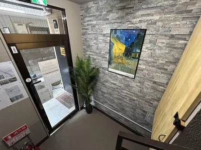 a room with a stone wall and a door with a plant at FIKA Shibuya Honmachi 101 in Tokyo