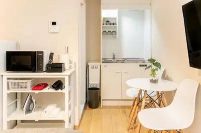 a small white kitchen with a small table and chairs at FIKA Shibuya Honmachi 101 in Tokyo