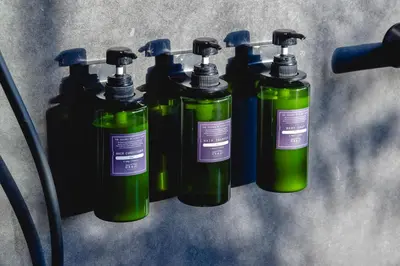 a group of four green bottles sitting on a table at YUURO Bath-Living Hotel Ryogoku in Tokyo