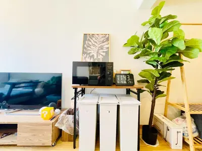 a table with a microwave and a plant in a room at Alo BnB 12 - Game Universe - Easy Access to Shibuya - New ! in Tokyo