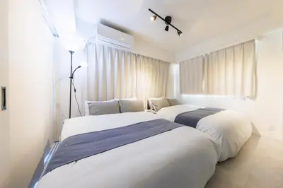 two beds in a room with white walls at Walk to Asakusa, Sky tree MAX16P in Tokyo