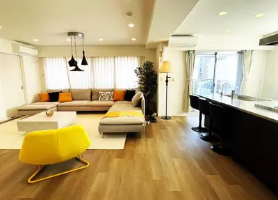 a living room with a couch and a yellow chair at Walk to Asakusa, Sky tree MAX16P in Tokyo