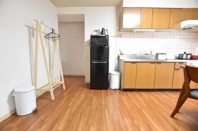 a kitchen with a black refrigerator and a wooden floor at Randor Residence Tokyo Grand in Tokyo