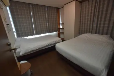 a small bedroom with two beds and a window at Randor Residence Tokyo Grand in Tokyo