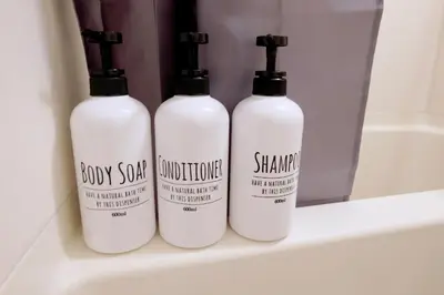 three bottles of body soap and shampoo sitting on a bathroom shelf at Heisei Mansion - Vacation STAY 17520 in Tokyo