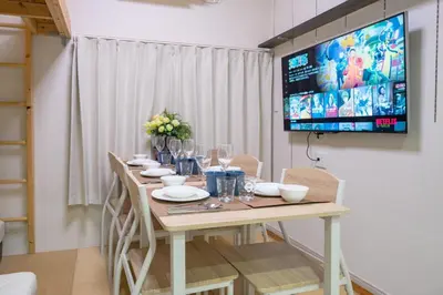 a dining room table with chairs and a tv on the wall at Kita Akabane-Diamond Yu - Vacation STAY 84219v in Tokyo