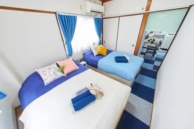 a bedroom with two beds and a balcony at Belmont 201 3min to Station Easy Access Ueno Asakusa Skytree Sleeps 5 in Tokyo