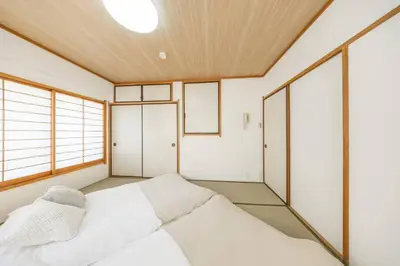 a bedroom with a white bed and a window at NewOpen! \u99c5\u5f92\u6b691\u5206 \u6c60\u888b\u30a8\u30ea\u30a2 60\u5e73\u7c73\u6700\u59278\u540d\u5bbf\u6cca\u53ef\u80fd \u548c\u98a8\u30e2\u30c0\u30f3 in Tokyo