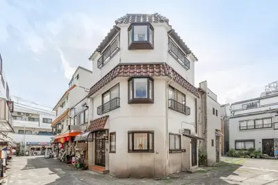 a tall white building with windows on a street at NewOpen! \u99c5\u5f92\u6b691\u5206 \u6c60\u888b\u30a8\u30ea\u30a2 60\u5e73\u7c73\u6700\u59278\u540d\u5bbf\u6cca\u53ef\u80fd \u548c\u98a8\u30e2\u30c0\u30f3 in Tokyo
