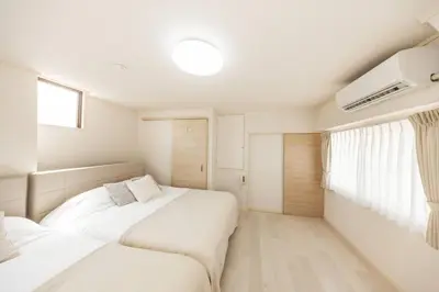 a bedroom with two beds and a window at NewOpen! \u99c5\u5f92\u6b691\u5206 \u6c60\u888b\u30a8\u30ea\u30a2 60\u5e73\u7c73\u6700\u59278\u540d\u5bbf\u6cca\u53ef\u80fd \u548c\u98a8\u30e2\u30c0\u30f3 in Tokyo