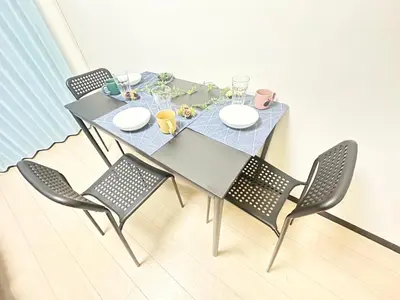 a dining table with four chairs and a blue table and chairs at \u65b0\u5bbf\u6b4c\u821e\u4f0e\u753a\u7acb\u5730\u6700\u9ad83\u30d9\u30c3\u30c9 in Tokyo