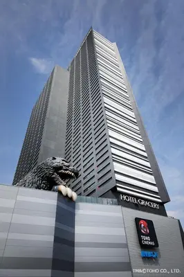 a tall building with a dinosaur statue in front of it at \u65b0\u5bbf\u6b4c\u821e\u4f0e\u753a\u7acb\u5730\u6700\u9ad83\u30d9\u30c3\u30c9 in Tokyo
