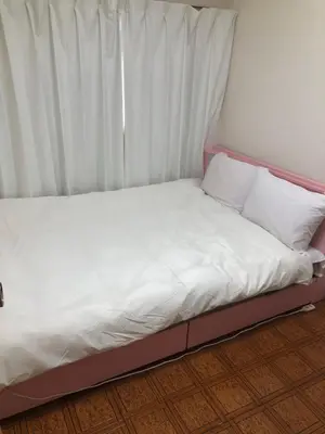 a bed with white sheets and pillows in a room at \u897f\u6c60\u888b\u4e4b\u5bb6 in Tokyo