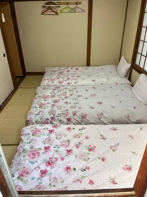 a bed with a floral comforter in a bedroom at \u897f\u6c60\u888b\u4e4b\u5bb6 in Tokyo