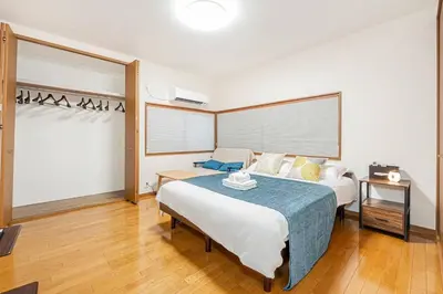 a bedroom with a large bed with a blue blanket at Tomo house in Tokyo