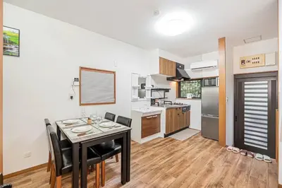 a kitchen with a table and chairs in a room at Tomo house in Tokyo