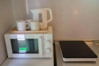 a microwave on a counter next to a laptop at \u65b0\u5bbf\u4e00\u7ad95\u5206\u949f-101-\u9910\u9986\u8d2d\u7269\u8857-\u5b89\u9759\u54c1\u8d28\u516c\u5bd3-\u76f4\u8fbe\u7687\u5c45\u79cb\u53f6\u539f in Tokyo