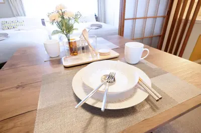 a table with a plate and forks and cups on it at Yoyogi Flats - Vacation STAY 17486 in Tokyo