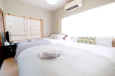 two white beds in a room with a window at Yoyogi Flats - Vacation STAY 17488 in Tokyo