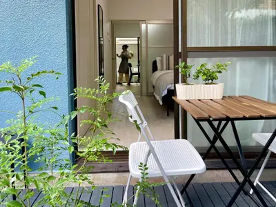 a balcony with a table and chairs and a bedroom at \u65b0\u5bbf\u4e00\u7ad95\u5206\u949f-102-\u9910\u9986\u8d2d\u7269\u8857-\u5b89\u9759\u54c1\u8d28\u516c\u5bd3-\u76f4\u8fbe\u7687\u5c45\u79cb\u53f6\u539f in Tokyo