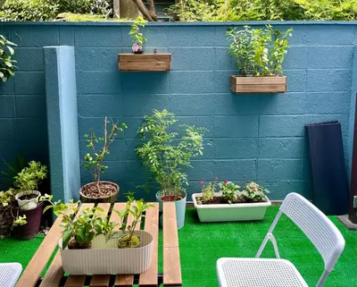 a patio with potted plants and chairs and a blue wall at \u65b0\u5bbf\u4e00\u7ad95\u5206\u949f-102-\u9910\u9986\u8d2d\u7269\u8857-\u5b89\u9759\u54c1\u8d28\u516c\u5bd3-\u76f4\u8fbe\u7687\u5c45\u79cb\u53f6\u539f in Tokyo