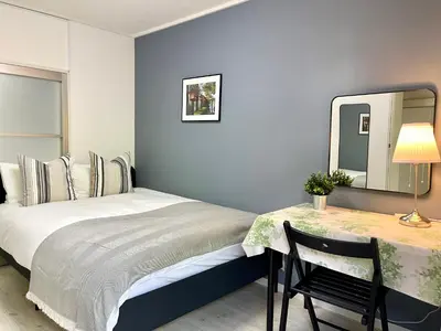 a bedroom with a bed and a table with a mirror at \u65b0\u5bbf\u4e00\u7ad95\u5206\u949f-102-\u9910\u9986\u8d2d\u7269\u8857-\u5b89\u9759\u54c1\u8d28\u516c\u5bd3-\u76f4\u8fbe\u7687\u5c45\u79cb\u53f6\u539f in Tokyo