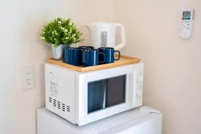 a microwave with blue mugs on top of it at \u65b0\u5bbf\u4e00\u7ad95\u5206\u949f-104-\u9910\u9986\u8d2d\u7269\u8857-\u5b89\u9759\u54c1\u8d28\u516c\u5bd3-\u76f4\u8fbe\u7687\u5c45\u79cb\u53f6\u539f in Tokyo