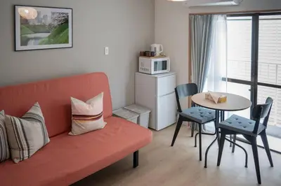 a living room with a couch and a table at \u65b0\u5bbf\u4e00\u7ad95\u5206\u949f-203-\u9910\u9986\u8d2d\u7269\u8857-\u5b89\u9759\u54c1\u8d28\u516c\u5bd3-\u76f4\u8fbe\u7687\u5c45\u79cb\u53f6\u539f in Tokyo