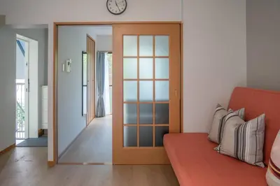 a living room with a couch and a clock on the wall at \u65b0\u5bbf\u4e00\u7ad95\u5206\u949f-203-\u9910\u9986\u8d2d\u7269\u8857-\u5b89\u9759\u54c1\u8d28\u516c\u5bd3-\u76f4\u8fbe\u7687\u5c45\u79cb\u53f6\u539f in Tokyo