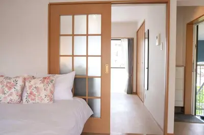 a bedroom with a bed and a sliding glass door at \u65b0\u5bbf\u4e00\u7ad95\u5206\u949f-204-\u9910\u9986\u8d2d\u7269\u8857-\u5b89\u9759\u54c1\u8d28\u516c\u5bd3-\u76f4\u8fbe\u7687\u5c45\u79cb\u53f6\u539f in Tokyo