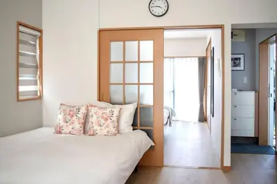 a bedroom with a bed and a clock on the wall at \u65b0\u5bbf\u4e00\u7ad95\u5206\u949f-204-\u9910\u9986\u8d2d\u7269\u8857-\u5b89\u9759\u54c1\u8d28\u516c\u5bd3-\u76f4\u8fbe\u7687\u5c45\u79cb\u53f6\u539f in Tokyo